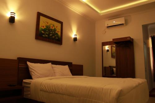 a bedroom with a bed and a mirror at Aluky Hotel in Majalengka