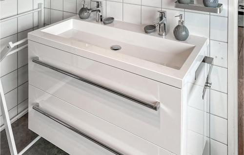 La salle de bains est pourvue d'un lavabo blanc et de carrelage blanc. dans l'établissement Cozy Apartment In Zoutelande With Wifi, à Zoutelande
