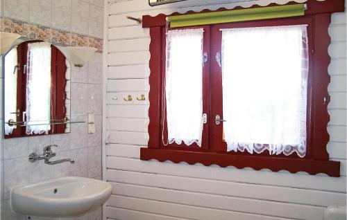 a bathroom with a sink and two windows at Awesome Home In Mscice With House Sea View in Mścice