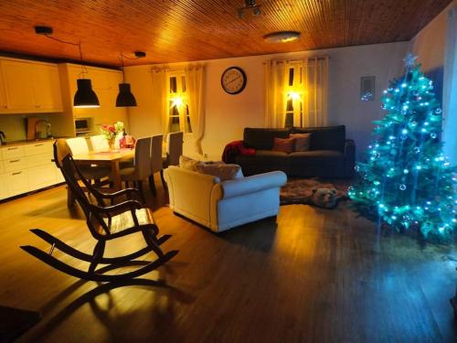 a living room with a christmas tree and a kitchen at Villa Tiiro in Ii