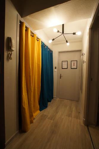 un pasillo con cortinas azules y amarillas en una habitación en L'@ppart, en Châtillon-sur-Chalaronne