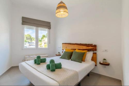 a bedroom with a large bed with two green towels at Casa Marina Moraira in Moraira