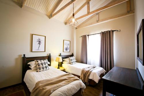 um quarto com 2 camas e uma janela em Otjiwa Safari Lodge em Otjiwarongo