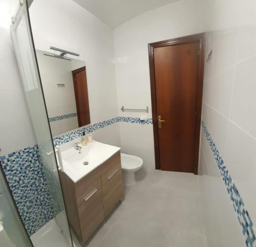 uma casa de banho com um lavatório, um WC e um espelho. em Renovado piso céntrico en Fuengirola em Fuengirola