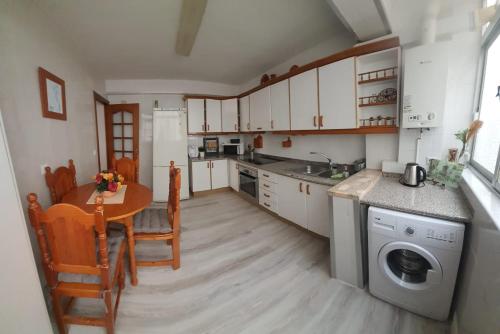 cocina con mesa, fregadero y lavavajillas en Renovado piso céntrico en Fuengirola en Fuengirola