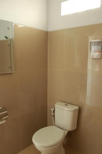 a bathroom with a white toilet and a window at Aluky Hotel in Majalengka
