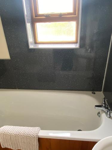 a bathroom with a bath tub and a window at The crown inn Longtown in Hereford