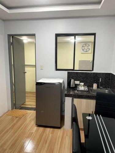 a kitchen with a counter and a refrigerator in a room at 3 - Cabanatuan City's Best Bed and Breakfast Place in Cabanatuan