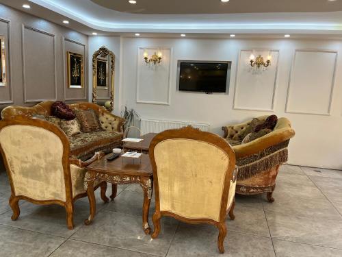 sala de estar con sofás, mesa y TV en Nova Roma Hotel, en Estambul