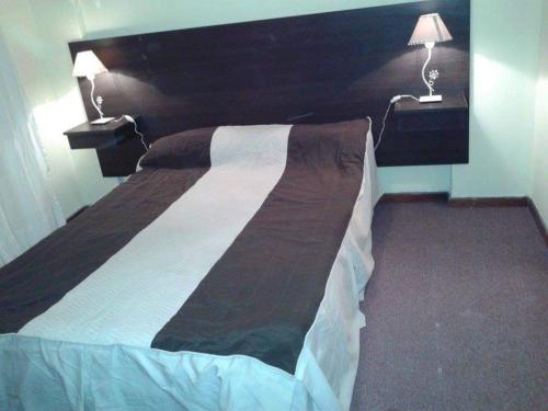 1 cama grande en un dormitorio con 2 lámparas en Alquilo dpto a cuadra de la playa en Necochea