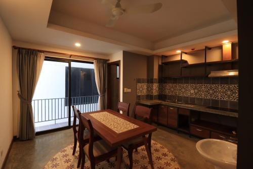 ein Esszimmer mit einem Tisch und einem Balkon in der Unterkunft Thean y apartment in Siem Reap