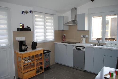 a kitchen with white cabinets and a sink at Le Clos de la Marquise in Amboise