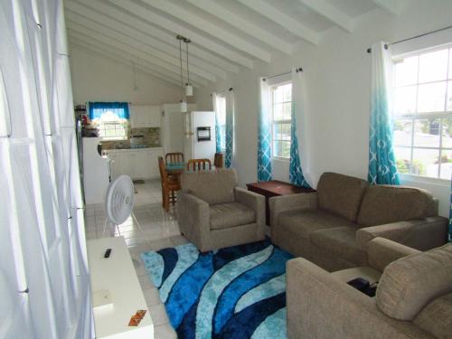 ein Wohnzimmer mit 2 Sofas und einer Küche in der Unterkunft Dover Apt 3 by the beach in the Gap in Christchurch