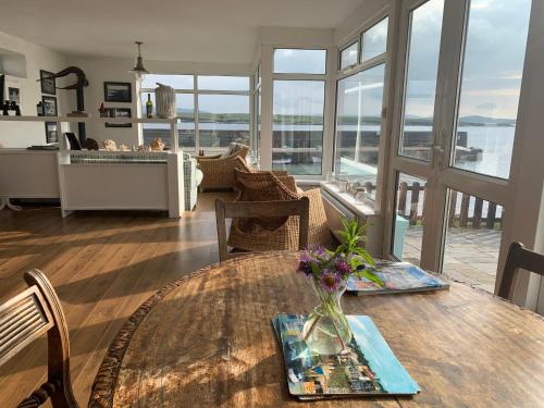 uma sala de jantar com uma mesa e vista para o oceano em Stunning Cottage on the Beach Portnoo Narin em Portnoo