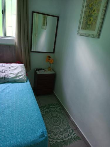 a small bedroom with a blue bed and a mirror at Pousada Decarli Executiva Aeroporto Florianópolis in Florianópolis