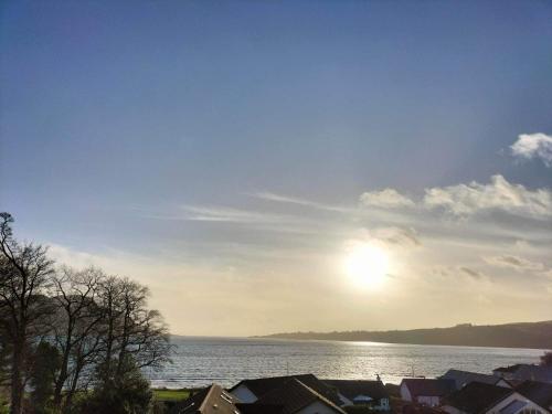 a view of the sun rising over a body of water at Seaview cosy 2 bed home in Lamlash in Lamlash