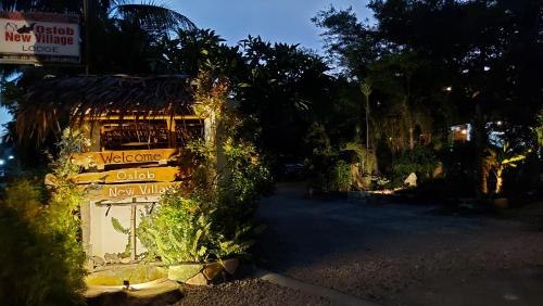 a welcome sign on the side of a building at New Village Lodge in Oslob
