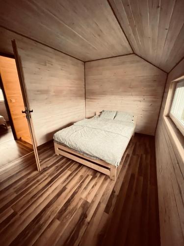a bedroom with a bed in a wooden room at BALTICO Domki Letniskowe in Sarbinowo