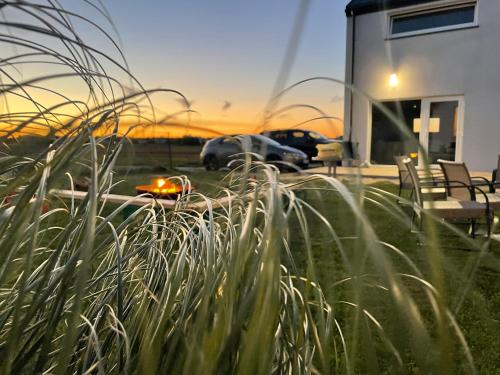 a view of a house with some grass in the foreground at BALTICO Domki Letniskowe in Sarbinowo