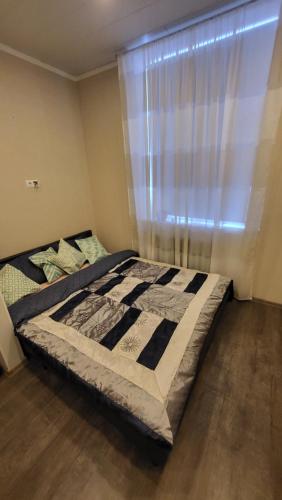 uma cama num quarto com uma janela em Kiviõli Apartment em Kiviõli