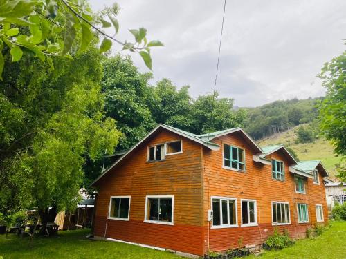 a wooden house in a yard with trees at Turismo Rural Los Alpes in Futaleufú
