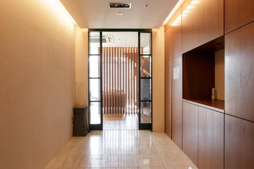 a hallway with a door leading into a building at スタンザベルデ名古屋 in Nagoya