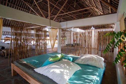 a bed with two pillows in a room at Rafiki Village in Watamu