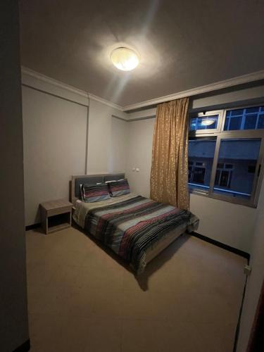 - une petite chambre avec un lit et une fenêtre dans l'établissement Dawa guest house, à Addis-Abeba