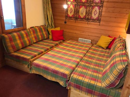 a couch and a bed in a room at appartement ski au pied in Valmorel