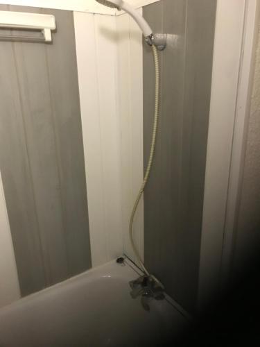a bathroom with a bath tub with a hose at appartement ski au pied in Valmorel