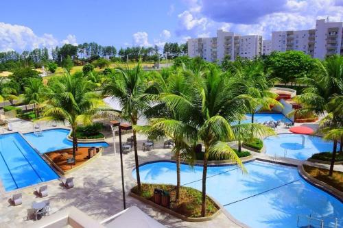 - une vue aérienne sur un complexe avec des palmiers et des piscines dans l'établissement Frente ao Parque da Lagoa Quente Entrada NÃO INCLUSA Aptos Particulares com varanda, à Caldas Novas