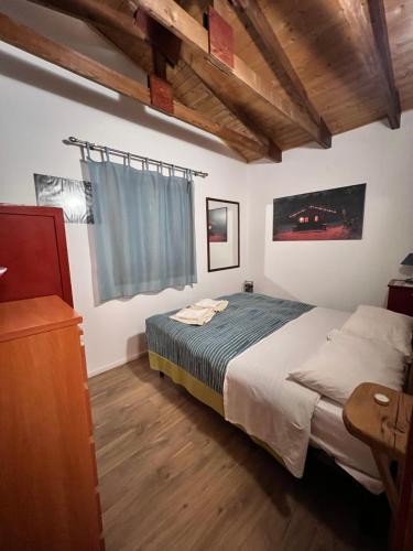 Schlafzimmer mit einem Bett und Holzboden in der Unterkunft La Baita del Convento - Il tuo rifugio sull'Etna in Nicolosi