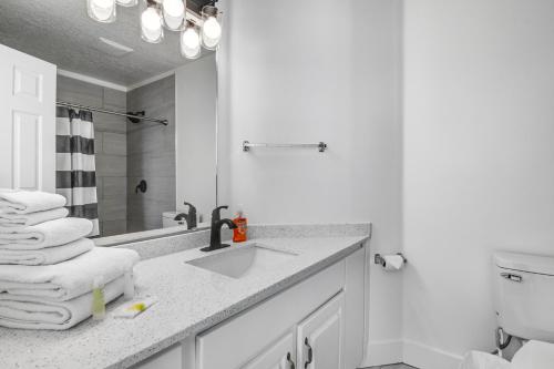 a white bathroom with a sink and a toilet at Harbor Village Retreat in Garden City