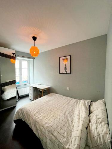 une chambre avec un lit, un bureau et une fenêtre dans l'établissement Location Granville - Remparts de la Hauteville, à Granville