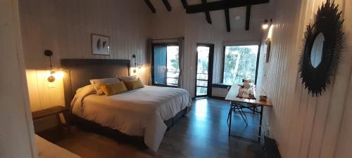 a bedroom with a bed and a large window at Cabañas Wildki Lodge Vichuquen in Curicó