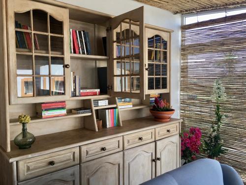 a room with a large wooden cabinet with books at Varandas do Vale Furnazinhas in Castro Marim