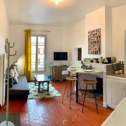 Le Logis des Cascades1 في موستيه سانت ماري: مطبخ وغرفة معيشة مع طاولة وكراسي