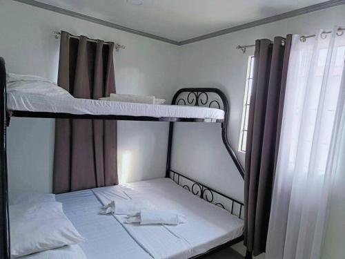 1 dormitorio con 2 literas y ventana en 4 - Affordable 2-Storey House in Cabanatuan City, en Cabanatúan