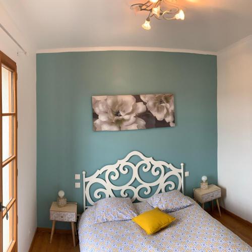 a bedroom with a bed with a blue wall at Le Logis des Cascades1 in Moustiers-Sainte-Marie