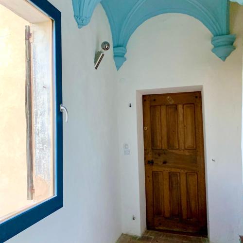 Pokój z niebieskim sufitem i drzwiami w obiekcie Le Logis des Cascades1 w mieście Moustiers-Sainte-Marie