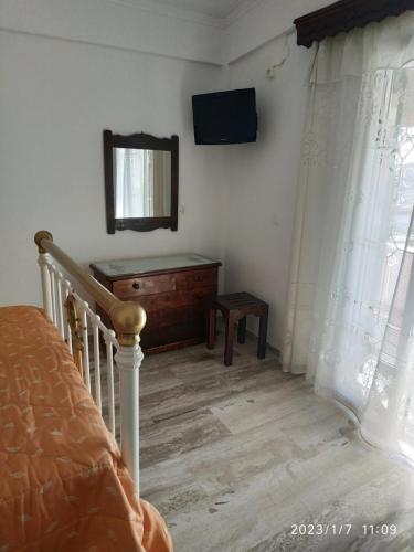 a bedroom with a bed and a dresser and a mirror at Gerekos Studios and Apartments in Agios Georgios