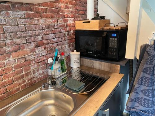 a kitchen counter with a sink and a microwave at Appartement - B&B de Koog in Uitgeest