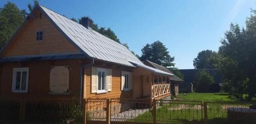 uma casa de madeira com uma cerca em frente em Dom Na Wsi u Ani em Koszele