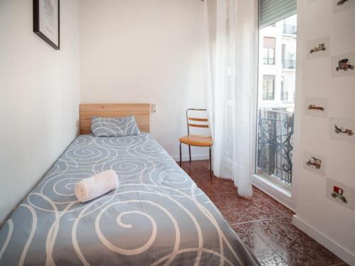 - une chambre avec un lit, une chaise et une fenêtre dans l'établissement AC Apartments Germanías, à Valence
