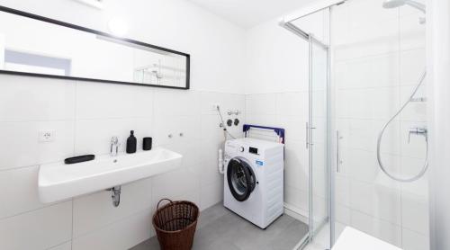 a white bathroom with a washing machine and a sink at Stay and Work Apartment - 6 single beds in Bocholt