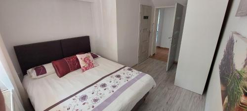 a bedroom with a large bed with red pillows at Apartament Eden Chopina in Karpacz