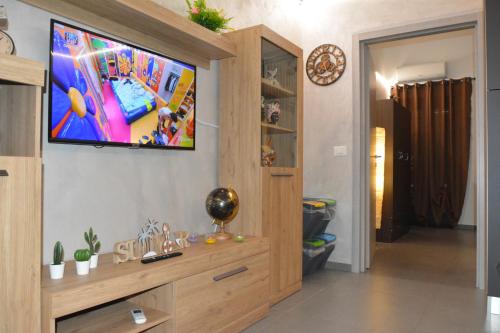sala de estar con TV de pantalla plana en la pared en House SantaFè2, en Catania