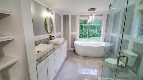 une salle de bain avec une baignoire, un lavabo et une douche dans l'établissement Hilltop Mansion at Rebecca's Fountain, à Niskayuna