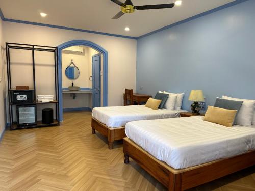 a bedroom with two beds and a ceiling fan at Sadakham Hotel in Luang Prabang