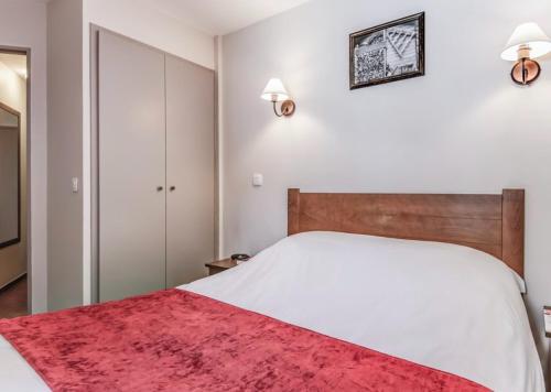 1 dormitorio con 1 cama blanca grande con alfombra roja en Résidence L’Albane en Vars